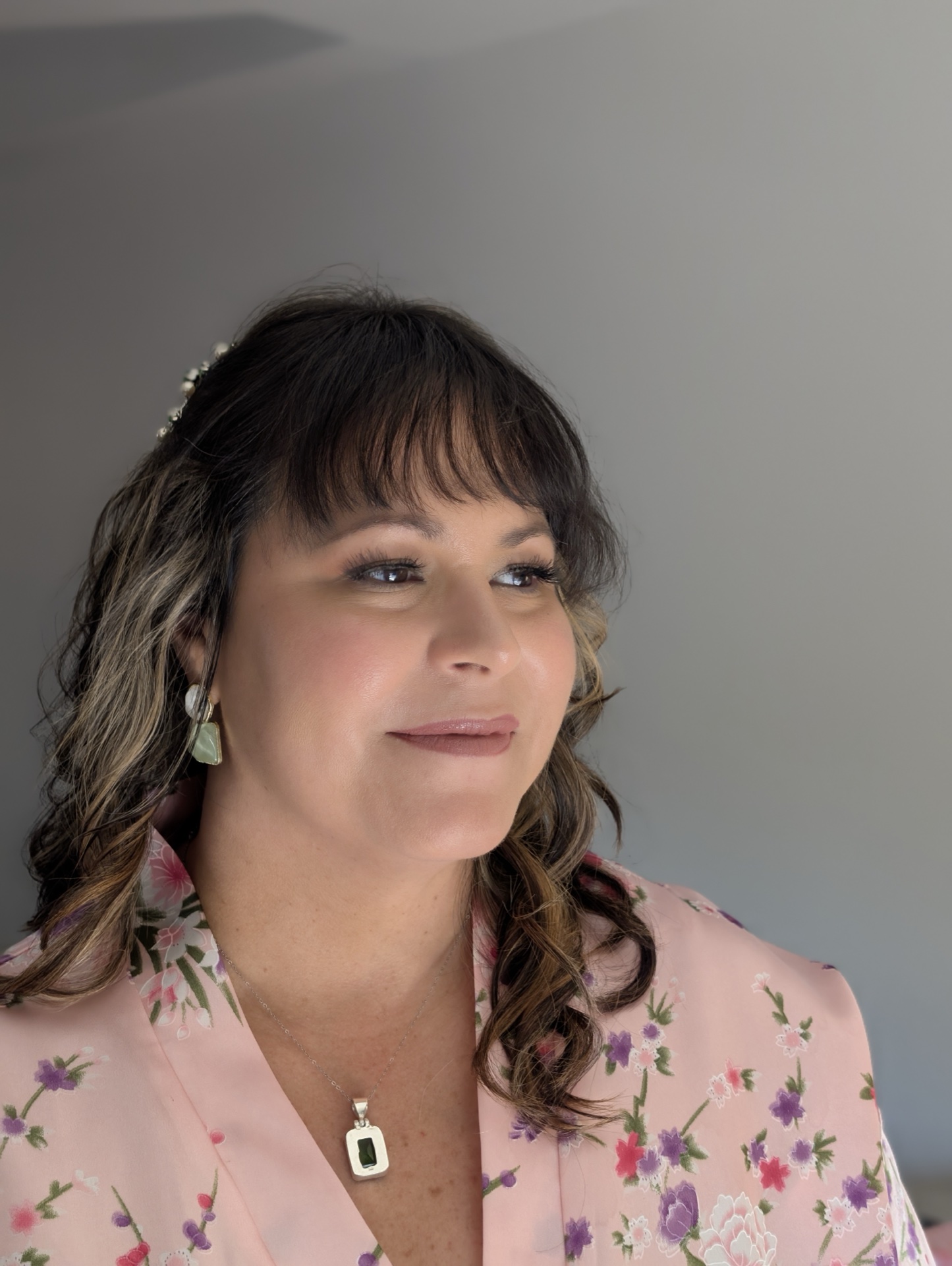 Natural glam wedding makeup and soft curls with floral hair accessory for multicultural bride NC